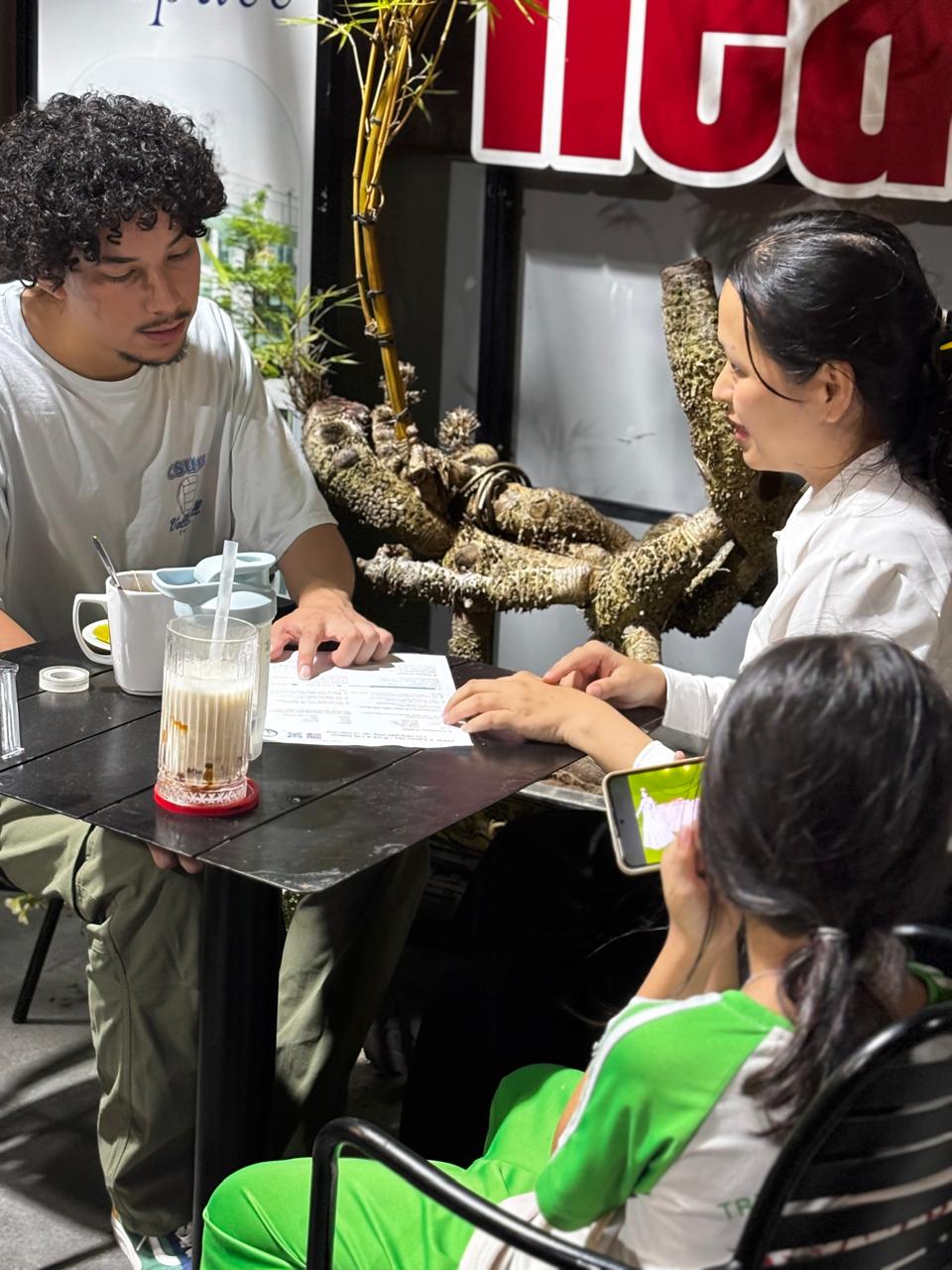 Two members practicing together at a table during the Friday, April 17, 2026 language exchange night.